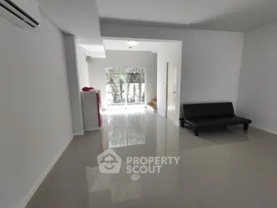 Spacious living room with glossy tiled floors and large window view