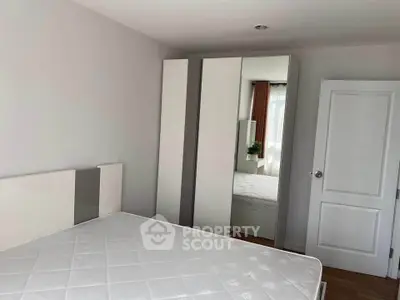 Spacious bedroom with modern white wardrobe and large window for natural light.