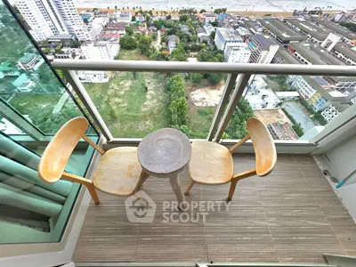 Stunning high-rise balcony with panoramic city views and cozy seating area.