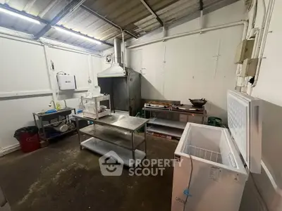Spacious industrial-style kitchen with stainless steel counters and large freezer, ideal for culinary ventures.