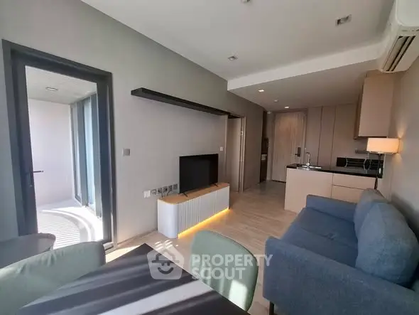 Modern living room with open kitchen and stylish furniture in a bright apartment.
