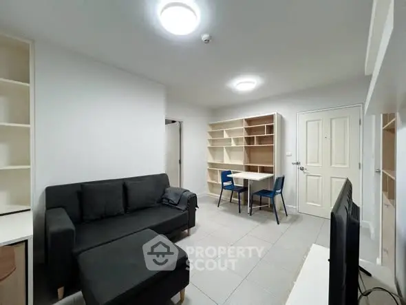 Modern living room with sleek black sofa and built-in shelving, perfect for urban living.