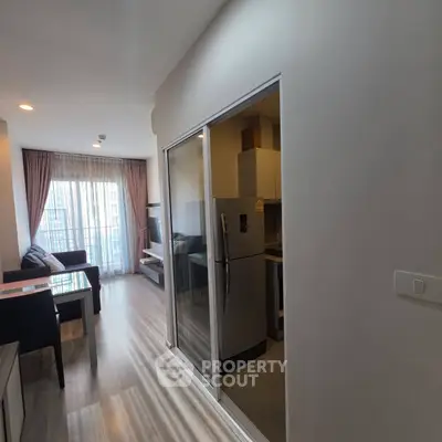 Modern apartment interior with open layout and natural light, featuring a cozy living area and sleek kitchen.