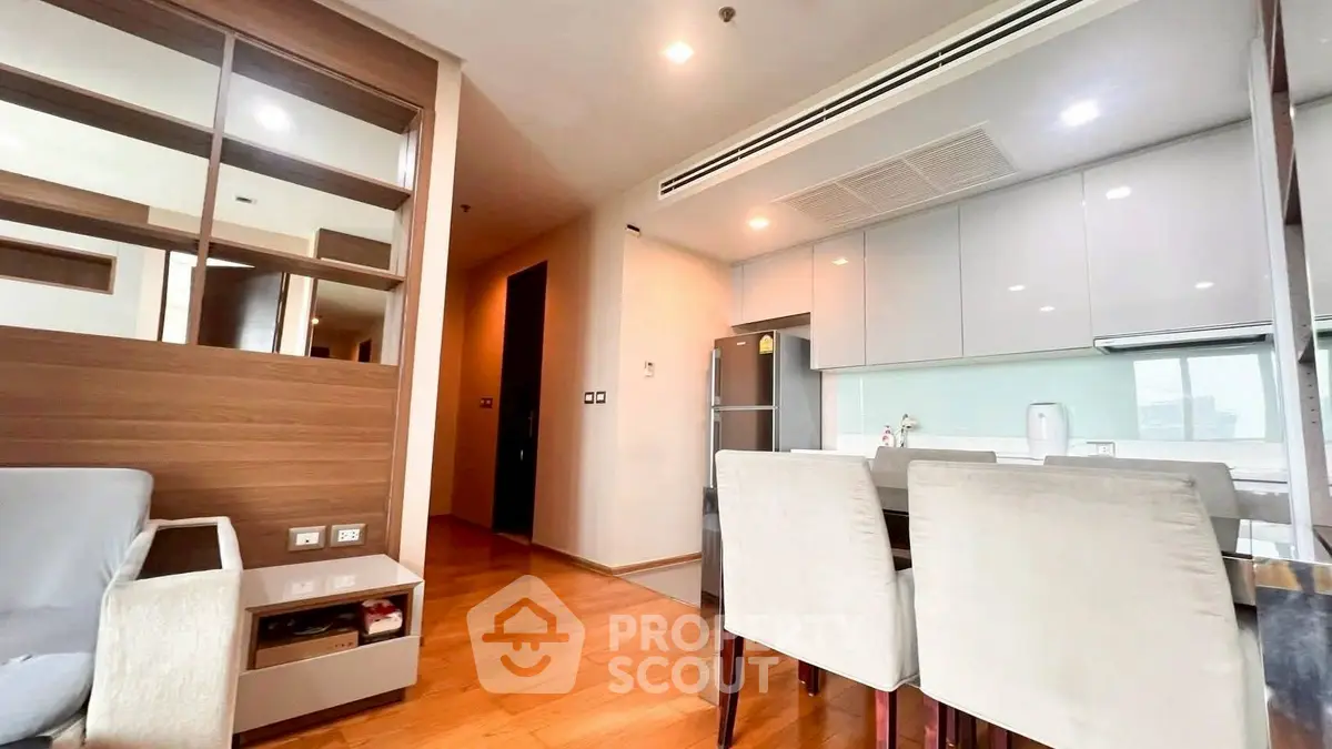 Modern open-plan living room and kitchen with sleek design and wooden flooring