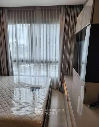 Modern bedroom with large window and sleek furniture in urban apartment