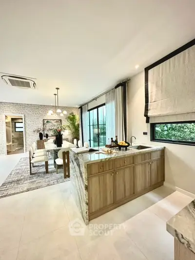 Luxurious open-plan kitchen and dining area with modern decor and large windows.