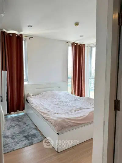 Cozy bedroom with large windows and elegant curtains in modern apartment