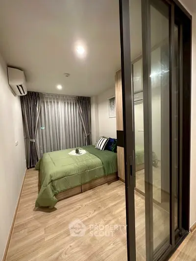Modern bedroom with sliding glass door and stylish decor in a cozy apartment.