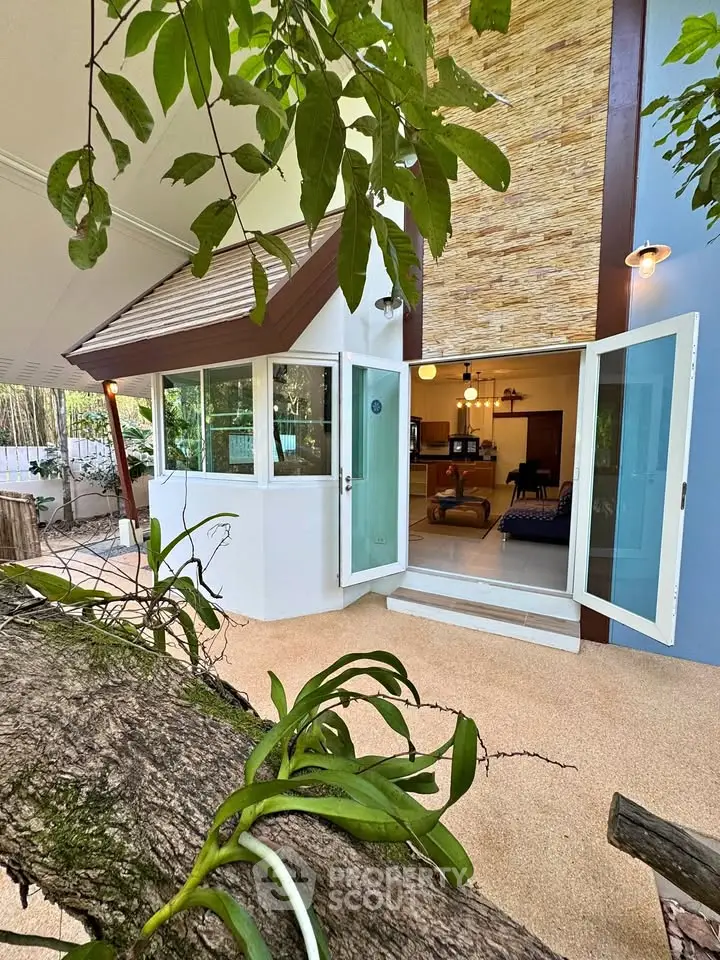 Charming modern home with open patio and lush greenery, perfect for serene living.