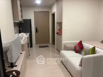 Modern compact living room with stylish furniture and open kitchen layout.