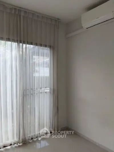 Bright room with large window and air conditioning, perfect for a cozy living space.