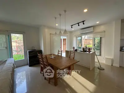 Spacious dining area with natural light and modern decor in a cozy home setting.