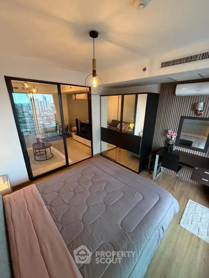 Modern bedroom with stylish decor and city view, featuring a cozy bed and sleek furniture.