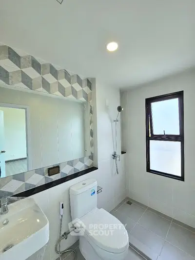 Modern bathroom with geometric tile design and natural light