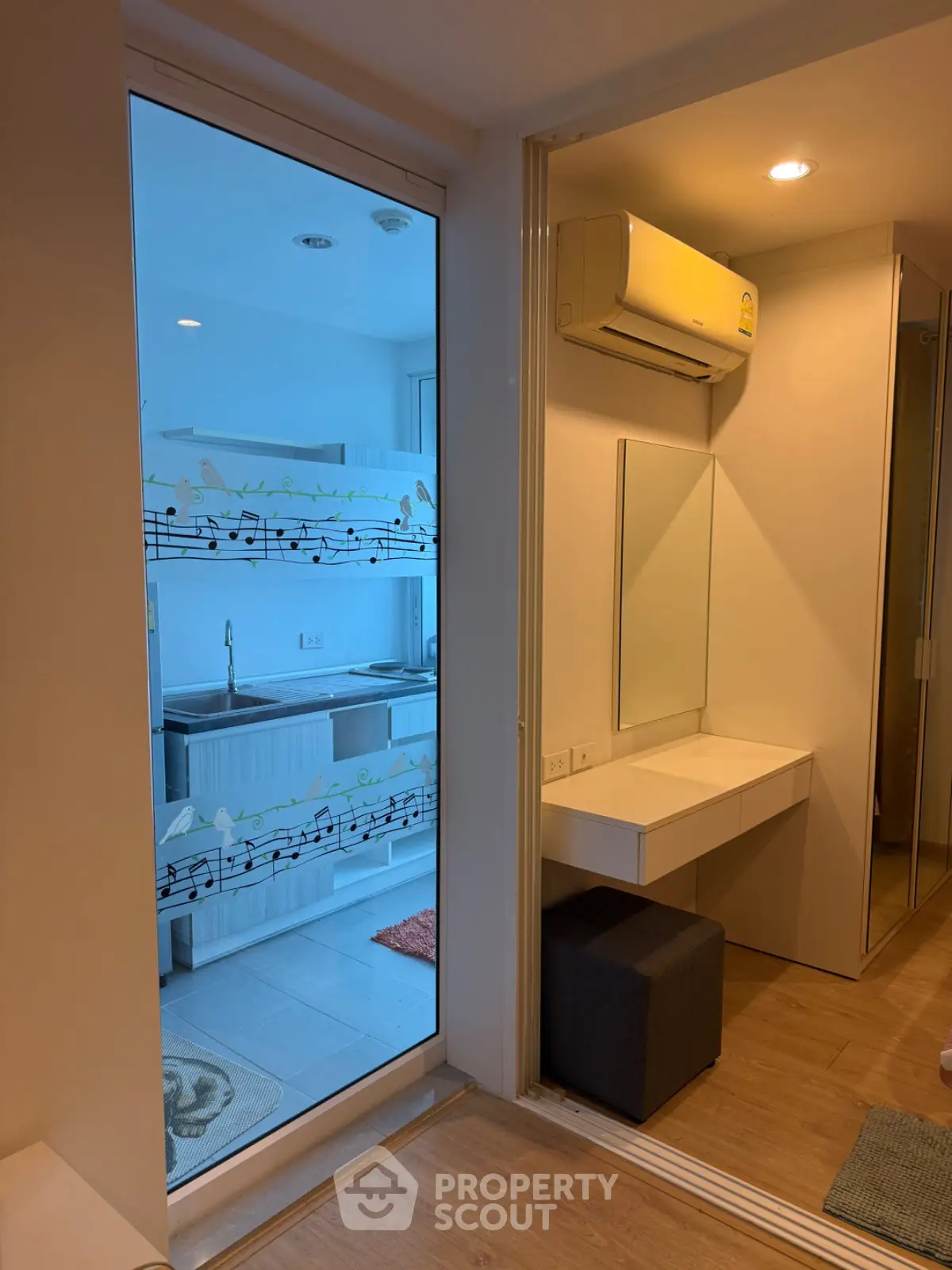 Modern apartment interior with stylish kitchen and vanity area, featuring sleek design and efficient use of space.