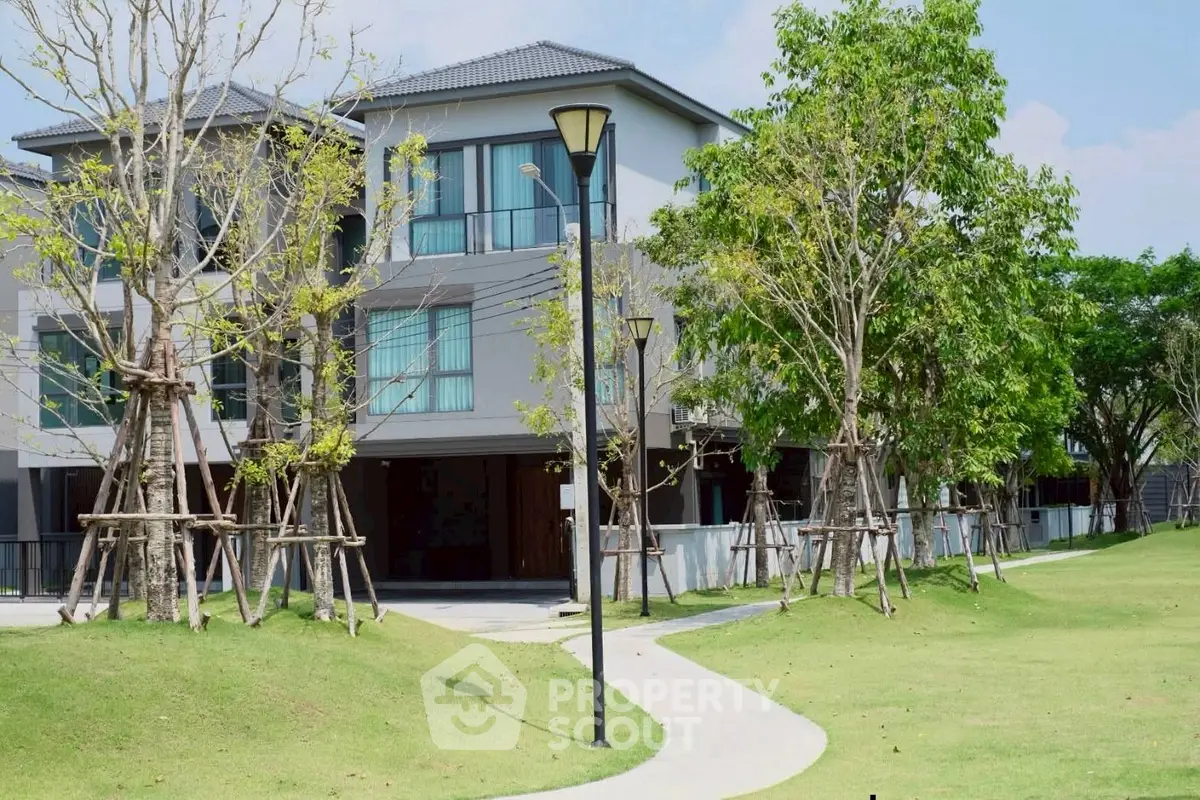 Modern residential building with lush green surroundings and well-maintained landscape.
