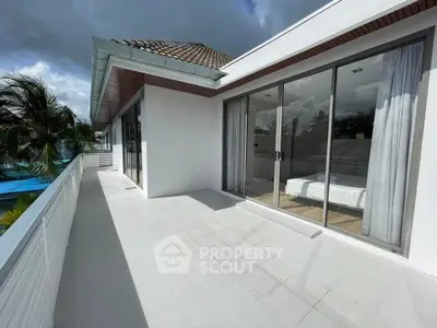 Luxurious villa with spacious balcony and stunning pool view, perfect for tropical living.
