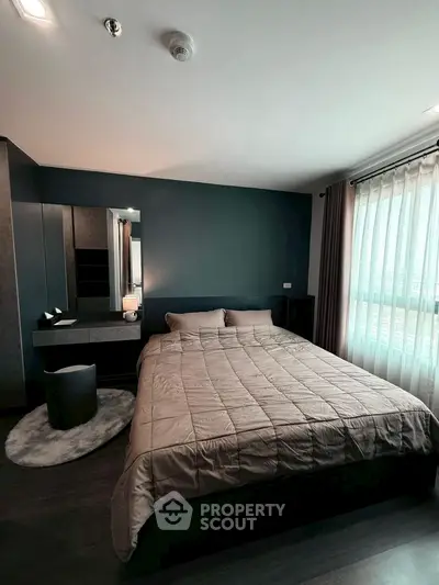 Modern bedroom with stylish decor and large window offering natural light.
