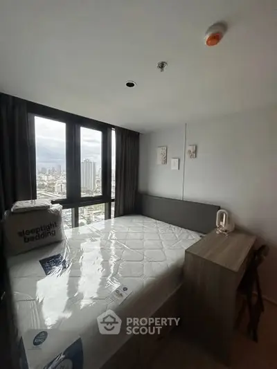 Cozy bedroom with city view, featuring a comfortable bed and modern decor in a high-rise apartment.