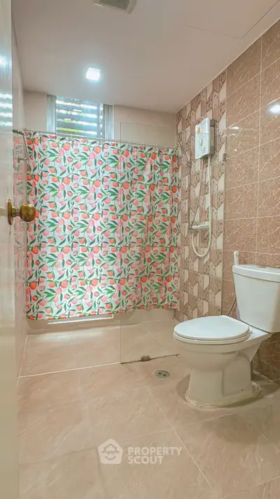 Charming bathroom with colorful shower curtain and modern fixtures in a cozy home.