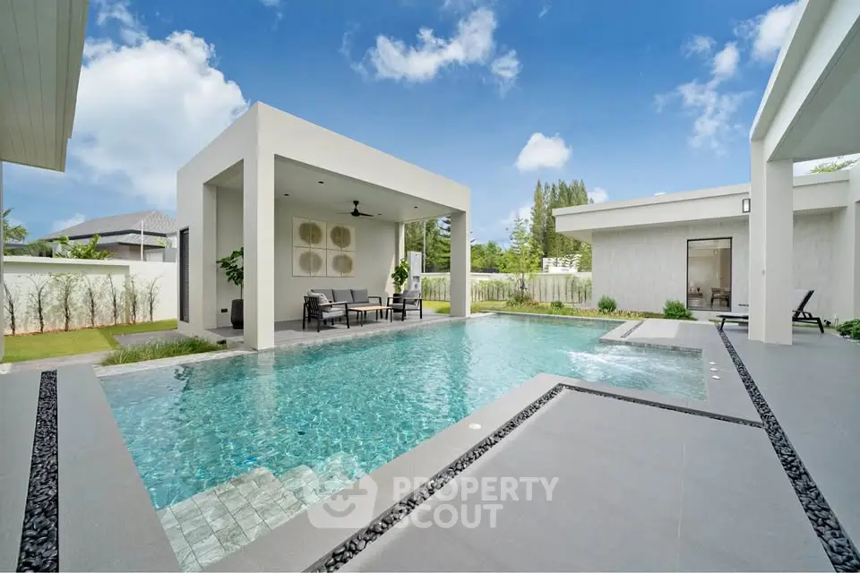 Luxurious modern villa with private pool and elegant outdoor seating area.