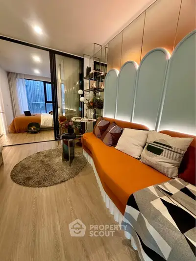 Stylish modern living room with orange sofa and cozy bedroom view