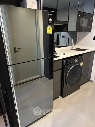 Modern kitchen with sleek appliances and stylish cabinetry in a contemporary apartment.
