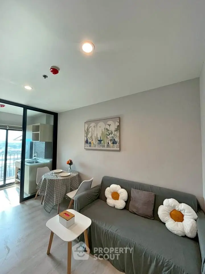 Modern living room with cozy sofa, stylish decor, and open kitchen layout in a bright apartment.