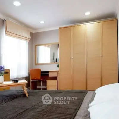 Cozy bedroom with modern furniture and ample natural light.