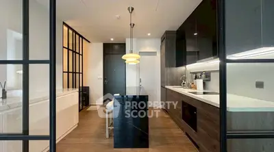 Modern kitchen with sleek black cabinetry and elegant lighting in a stylish apartment.