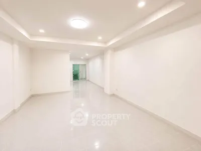 Spacious empty room with tiled flooring and recessed lighting, ideal for customization.
