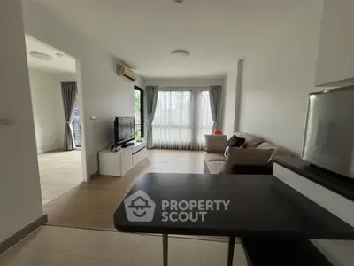 Spacious modern living room with natural light and stylish furniture in a contemporary apartment.