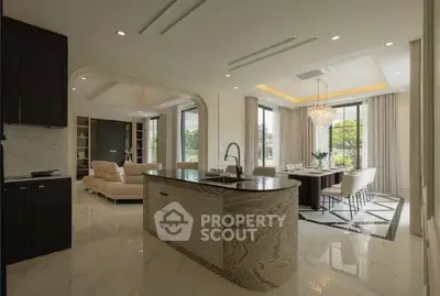 Luxurious open-plan kitchen and dining area with elegant chandelier and marble flooring.