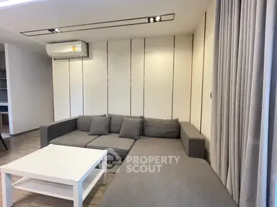 Modern living room with cozy gray sectional sofa and sleek white coffee table