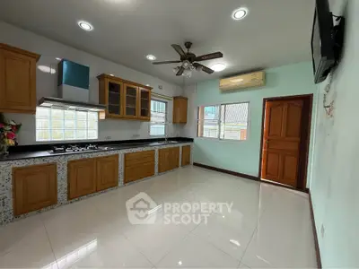 Spacious kitchen with wooden cabinets and modern appliances in a bright home.
