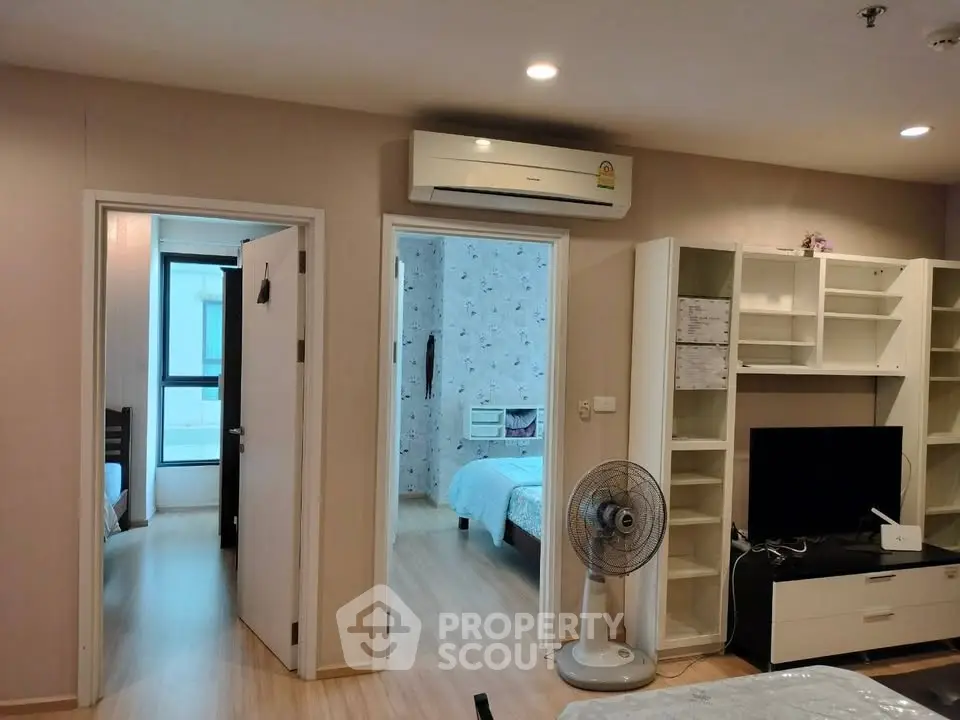 Spacious apartment interior with modern living room and two bedrooms, featuring air conditioning and stylish decor.