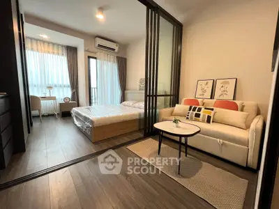 Modern studio apartment with glass partition, cozy living area, and natural light.