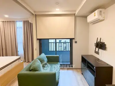 Modern living room with green sofa and balcony view in stylish apartment