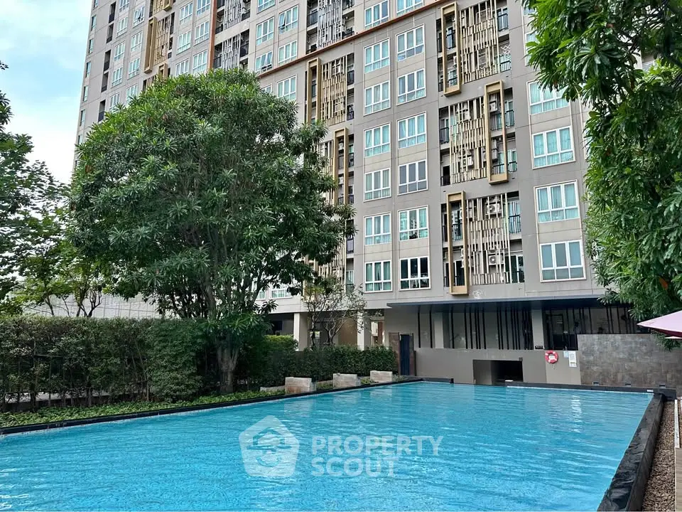 Modern condominium with a refreshing outdoor pool and lush greenery, perfect for relaxation and leisure.