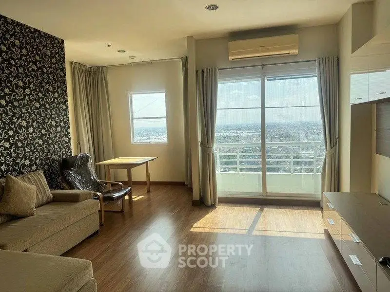 Spacious living room with large window offering stunning city view, modern decor, and ample natural light.