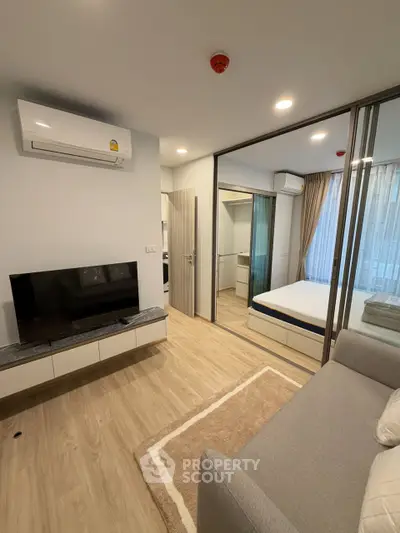 Modern apartment interior with cozy living room and bedroom, featuring sleek design and natural light.