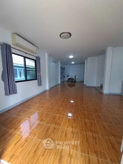Spacious living room with wooden flooring and ample natural light