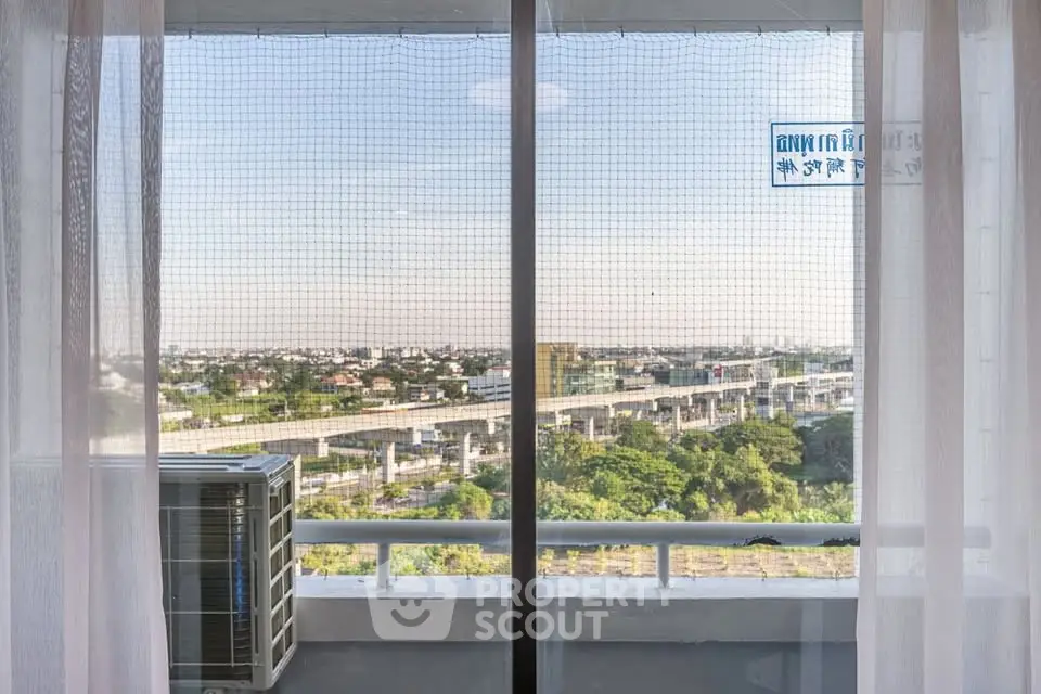 Stunning high-rise apartment view with expansive cityscape and lush greenery, perfect for urban living.