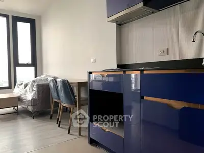 Modern kitchen with blue cabinets and dining area in a bright apartment