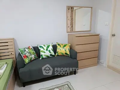 Cozy bedroom with stylish sofa and vibrant decor pillows, perfect for relaxation and comfort.