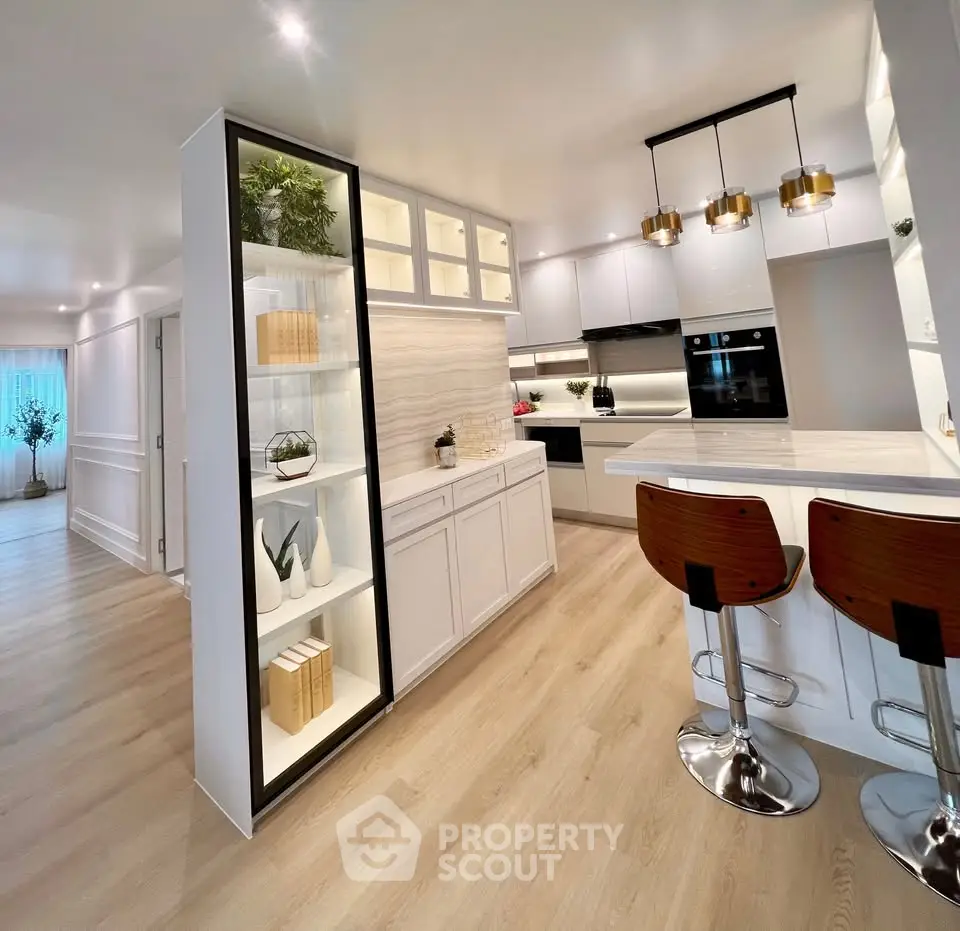 Luxurious modern kitchen with sleek design and open layout, featuring high-end appliances and stylish lighting.
