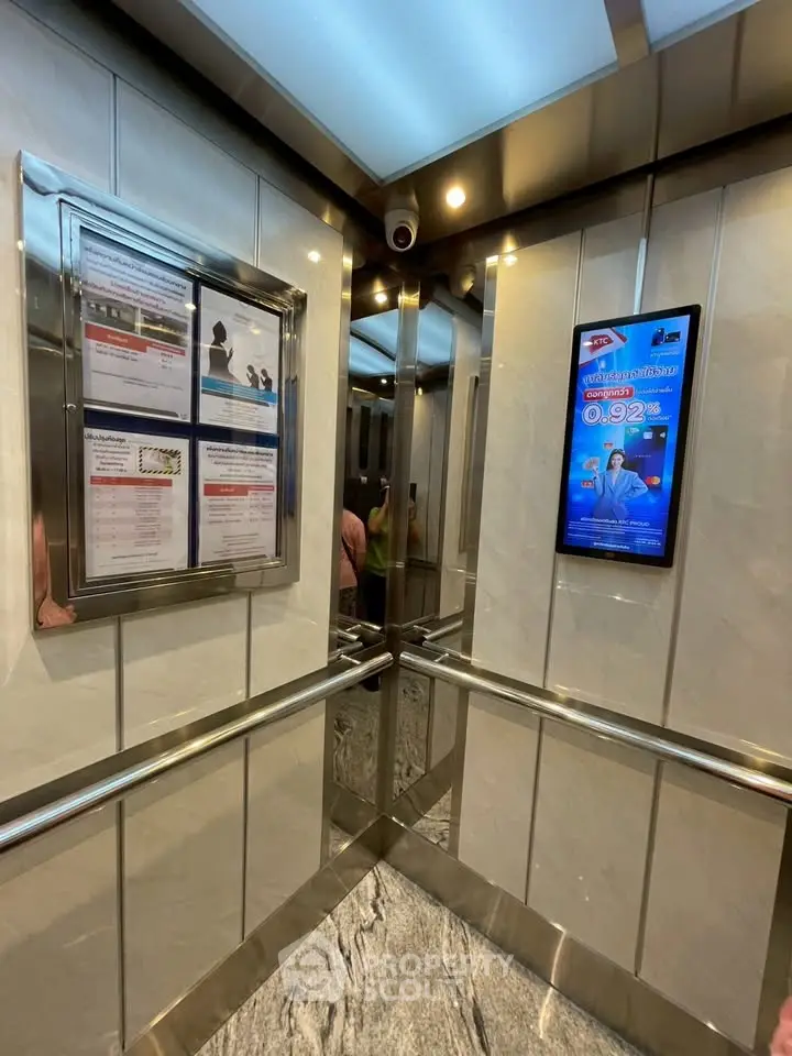 Modern elevator interior with sleek design and digital display in a residential building.