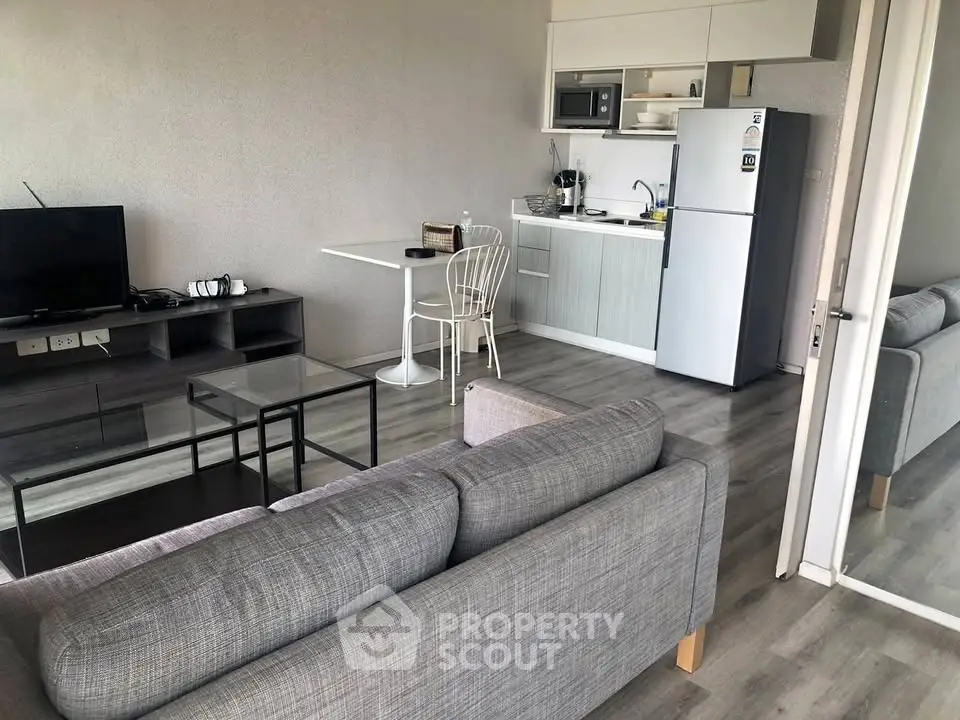 Modern open-plan living room with sleek kitchen and cozy seating area.