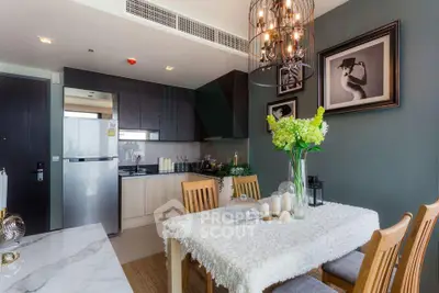 Modern dining area with elegant decor and open kitchen layout in stylish apartment.