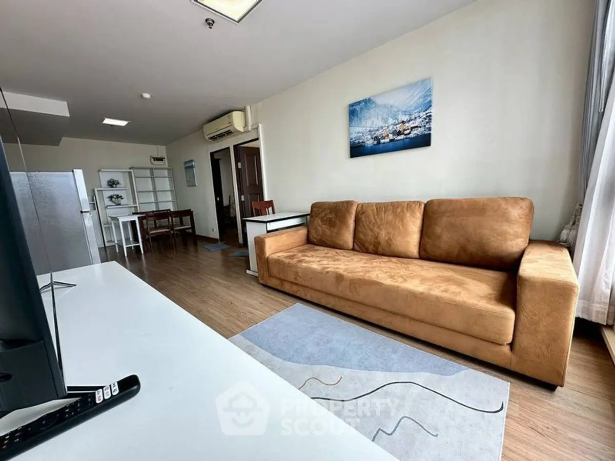 Spacious living room with modern decor and large sofa in a bright apartment.